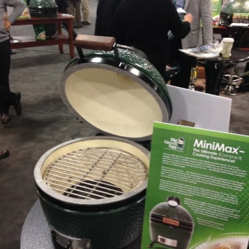 Big Green Egg has announced today the release of the newest offering to it's quiver of cookers. It is called the Mini-Max and it was unveiled today at the Hearth, Patio, and Barbecue Expo in Salt Lake City, UT. For the habitual Big Green Egg enthusiast, one look at the Mini-Max and you can tell some serious thought and work went into this one. The first thing you notice from the exterior is that the thermometer is about twice as large as the thermometers on the current Big Green Egg offerings. A gentleman pointed out to me that his eyesight is not quite as spry as it once was and he already finds the larger thermometer easier to read. When you open the Mini-Max, it has the same cooking area as the Small Big Green Egg, 13 inches in diameter. But what is noticeably different is that the bottom fire grate on the Mini-Max measures 10.5 inches across. In comparison, the bottom fire grate on the Small Big Green Egg measures in about half that size at 5.5 inches. This means more air flow for the Mini-Max and more control over what you are cooking!