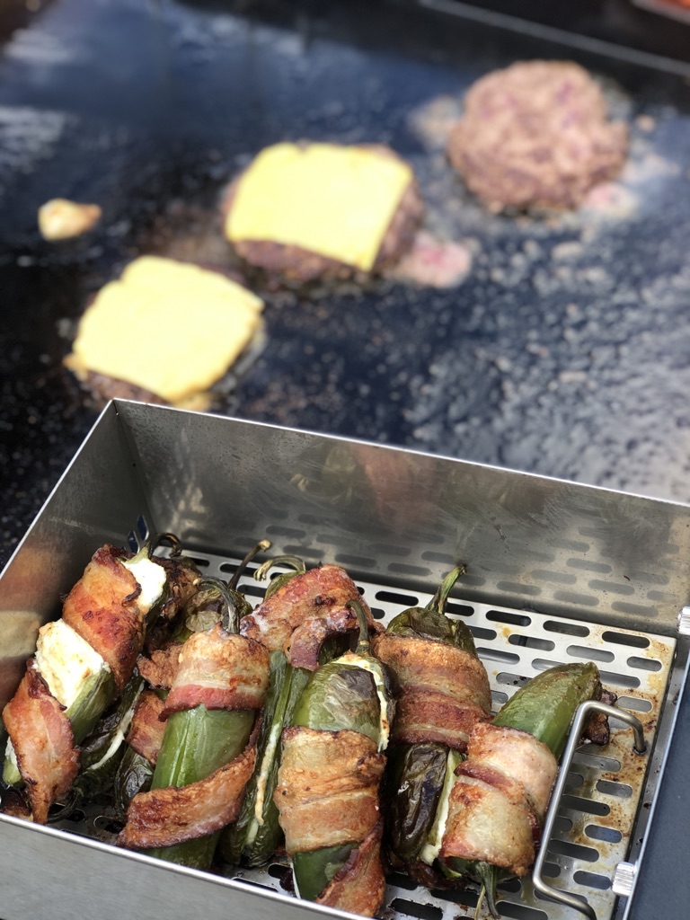 air fryer basket with food and burgers on griddle