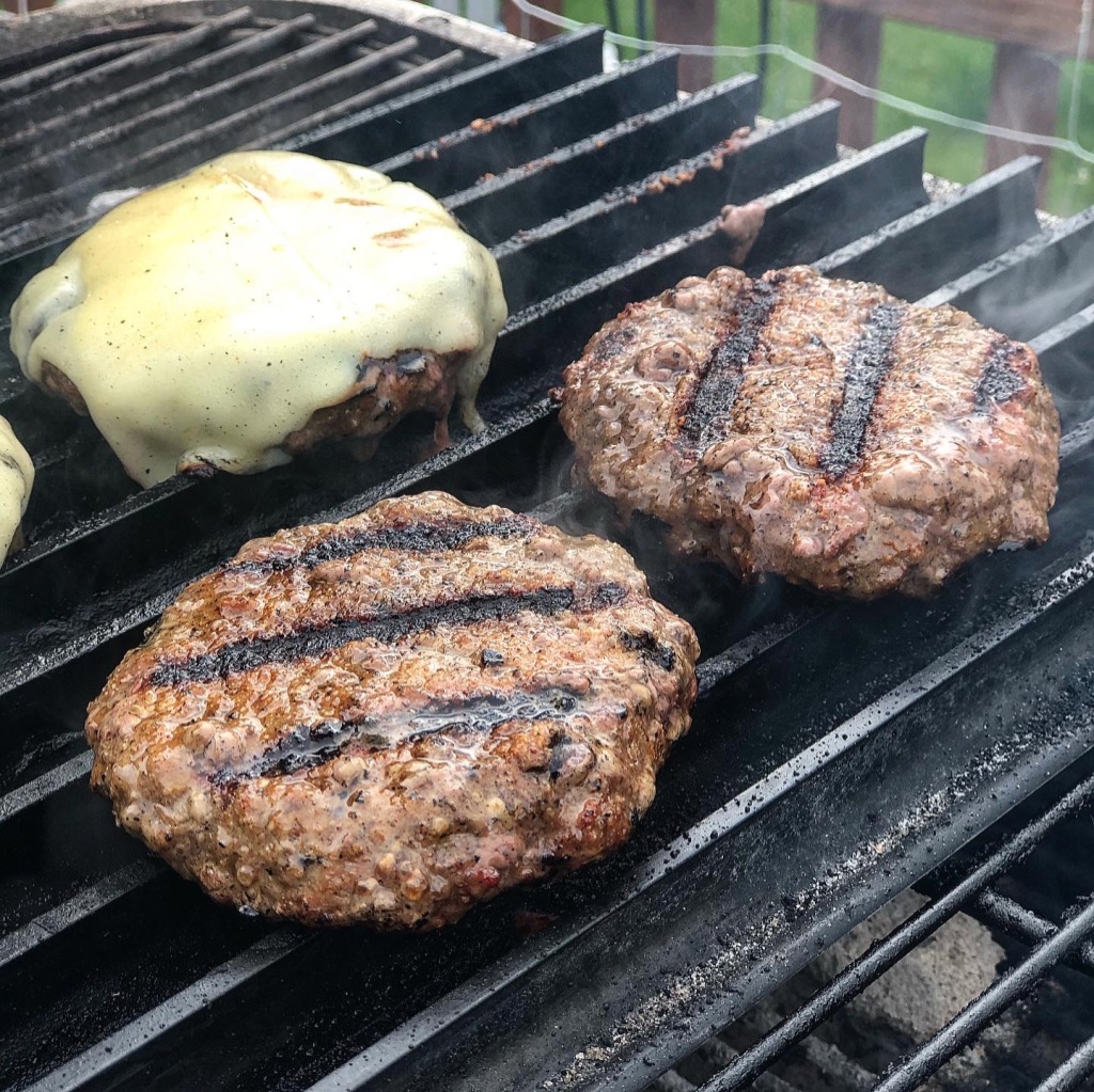 Burgers cooking outdoors on GrillGrates