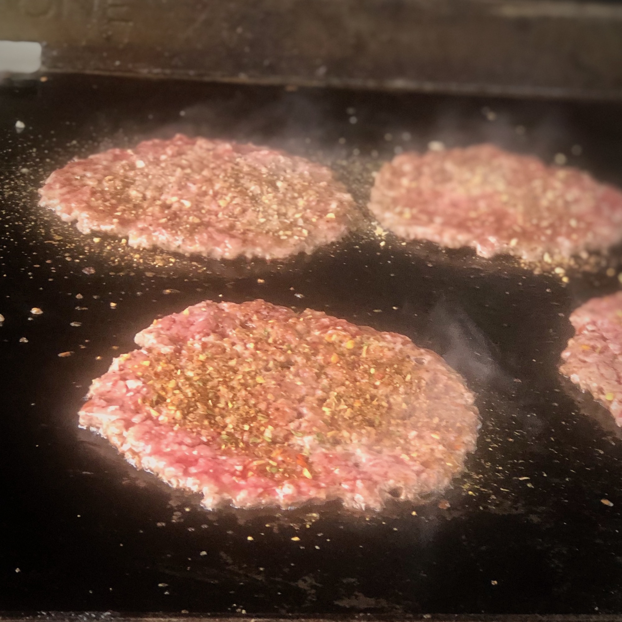 burgers cooking on griddle