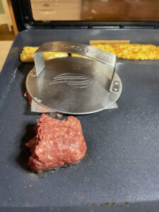 pressing burger on griddle