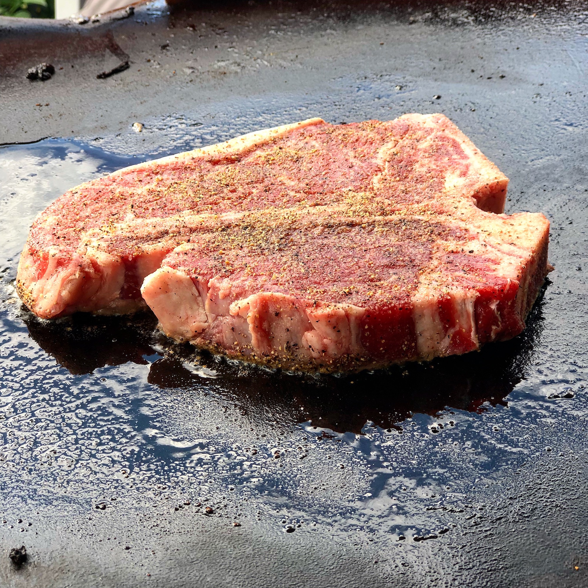 steak cooking on a griddle grill